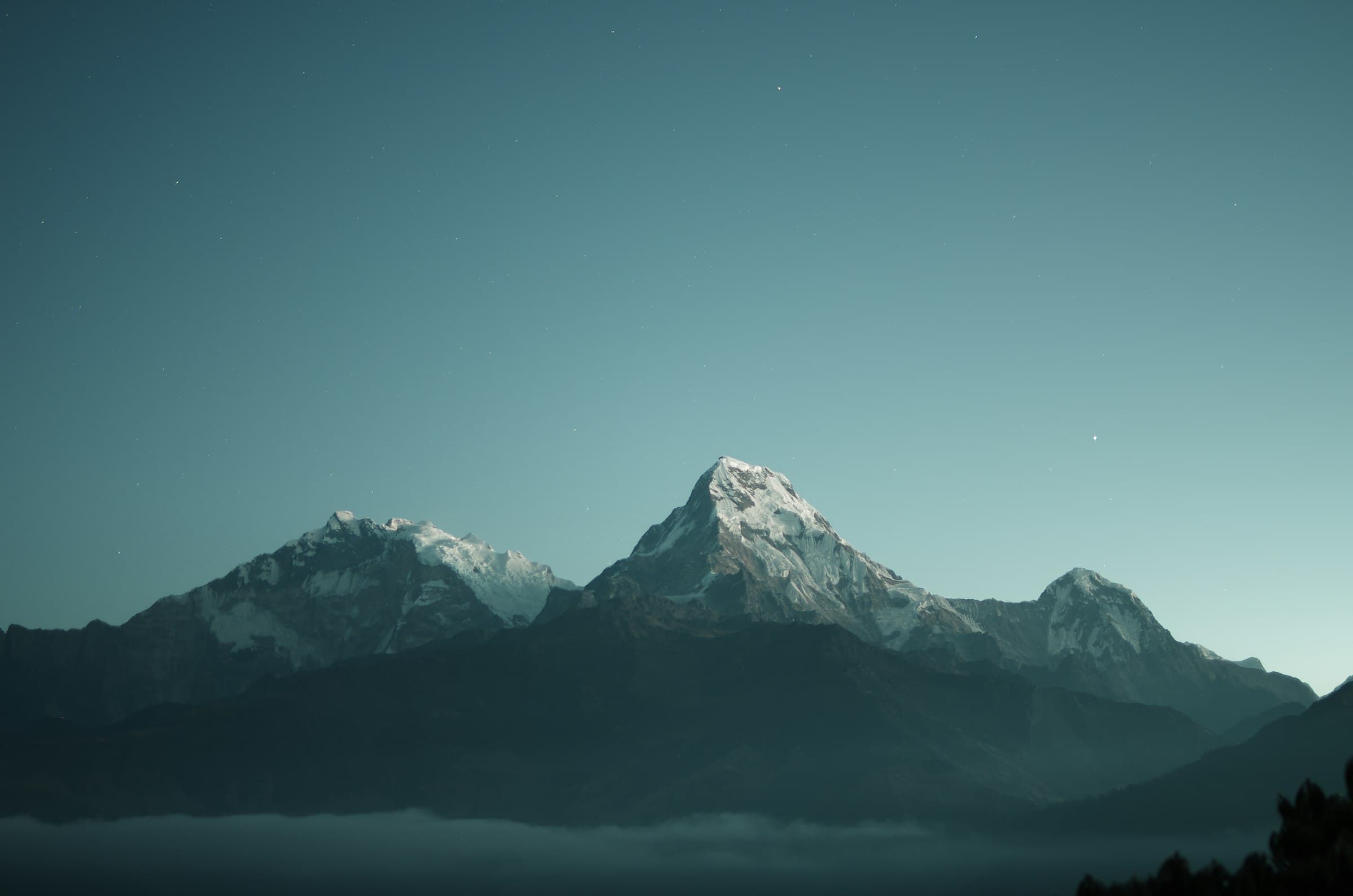 Snow-capped Himalayan peaks beneath a clear dusk sky